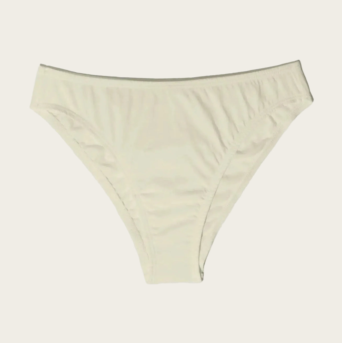 A pair of low-rise, high-waisted bikini bottoms in a light cream or off-white color, displayed flat against a light gray background. A small brown circular badge in the top-left corner reads 'skin sensitive'.