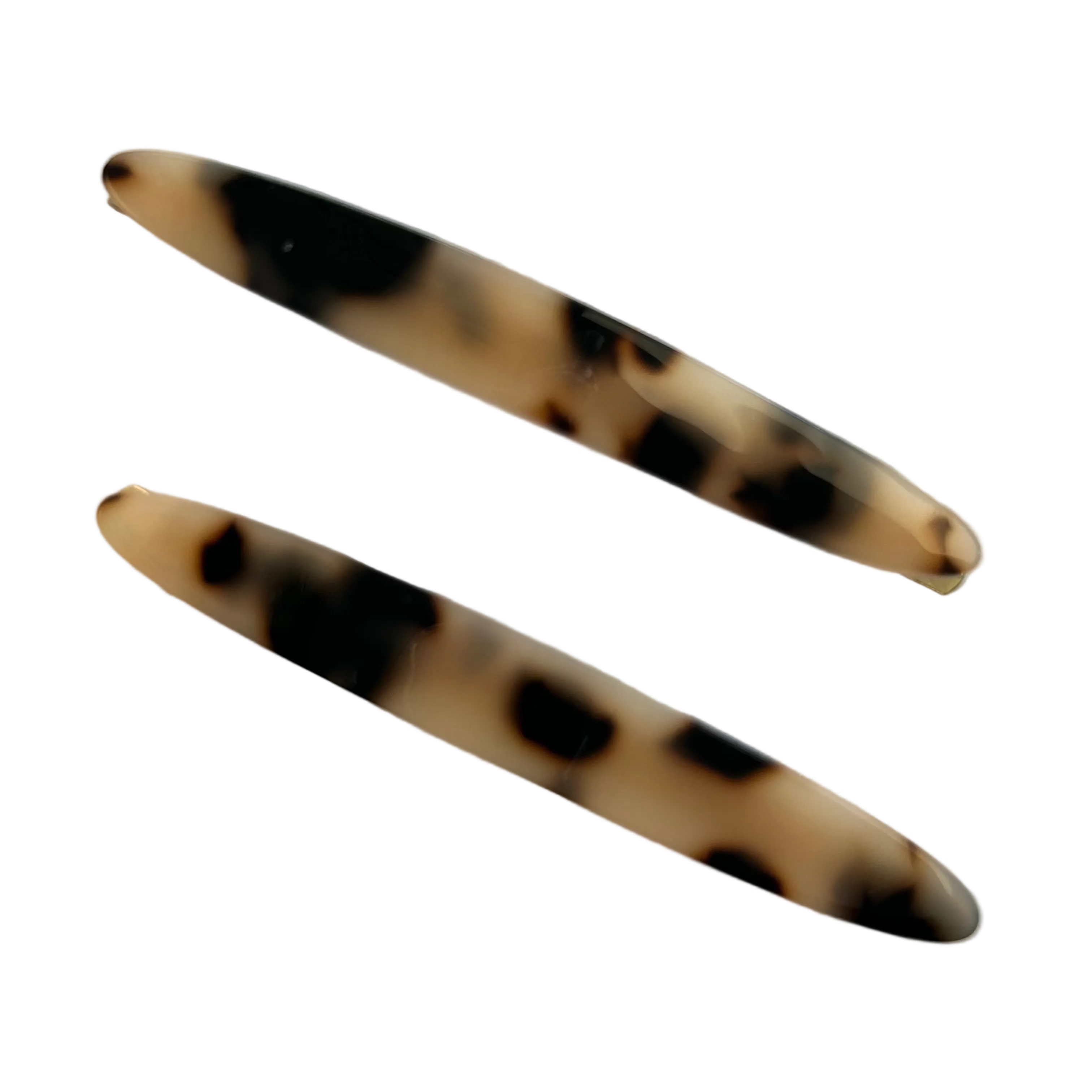 Two tortoiseshell patterned hair pins on a light gray background