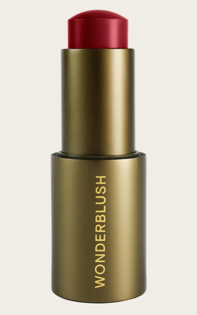 Bronze-colored blush stick with red cap on a light gray background