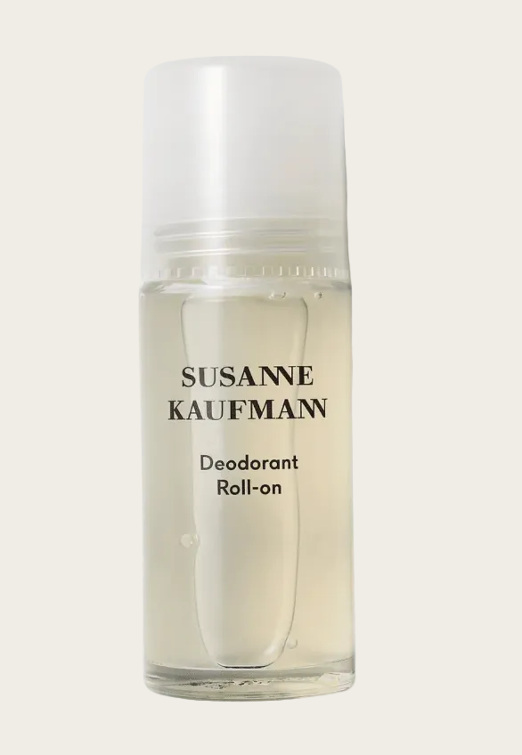 A clear cylindrical bottle of Susanne Kaufmann Deodorant Roll-on with a frosted cap, containing a pale yellow liquid, set against a light gray background with a soft shadow.