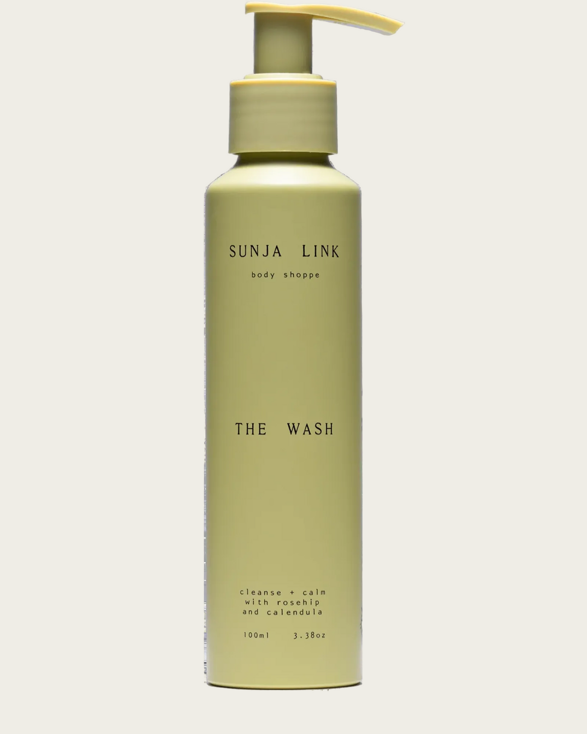 A 150ml pump bottle of SUNJA LINK 'The Wash' body shop cleanser, in a muted sage green color with a matching pale yellow-green pump dispenser, shown against a plain white background.