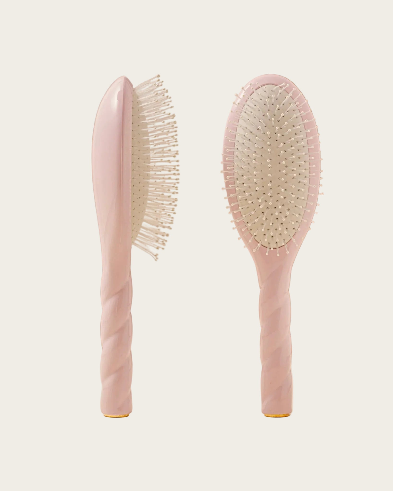 Two pink hairbrushes on a beige background with a 'Marie Claire Hair Awards Winner' badge.
