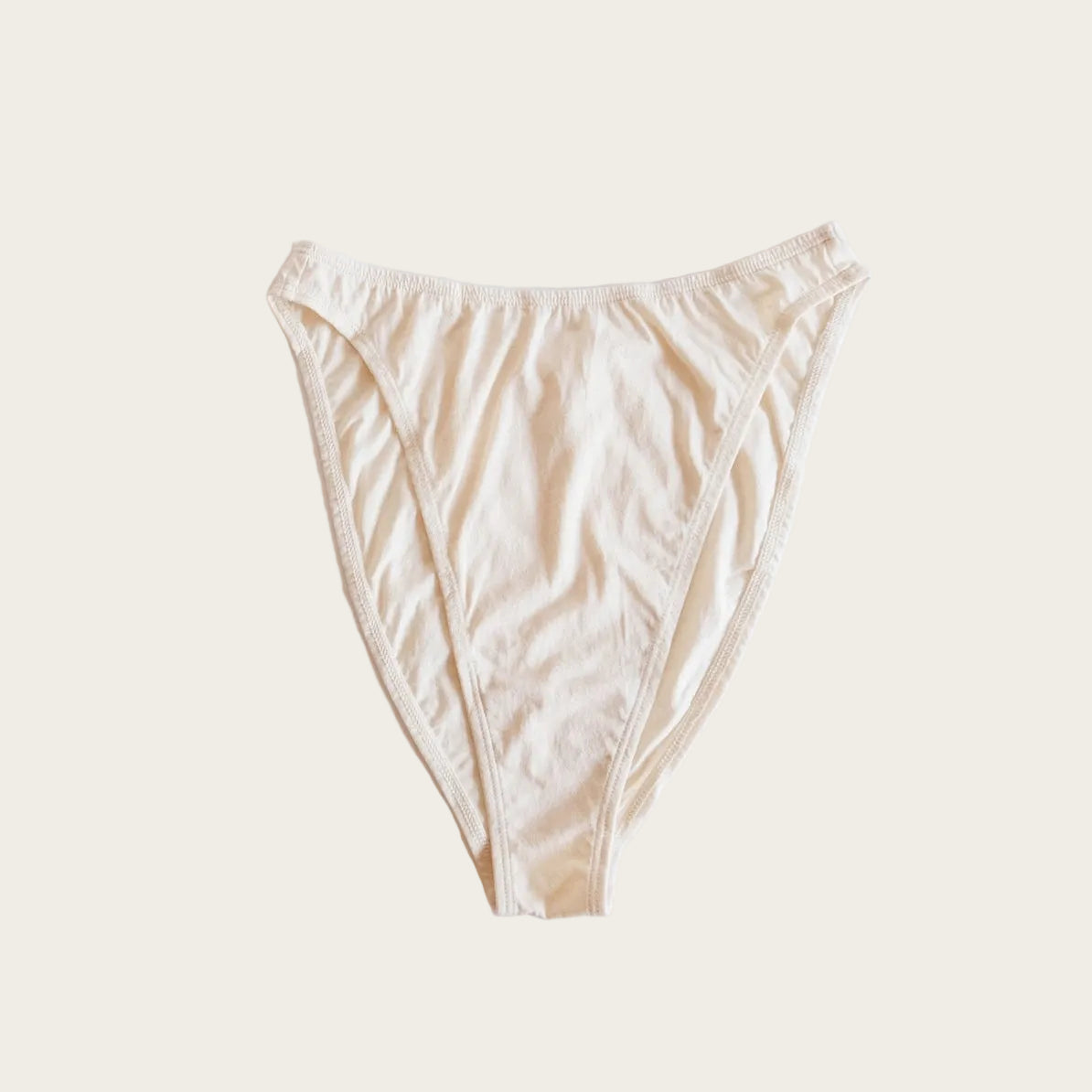 A light beige low-rise bikini bottom laid flat on a clean white background.