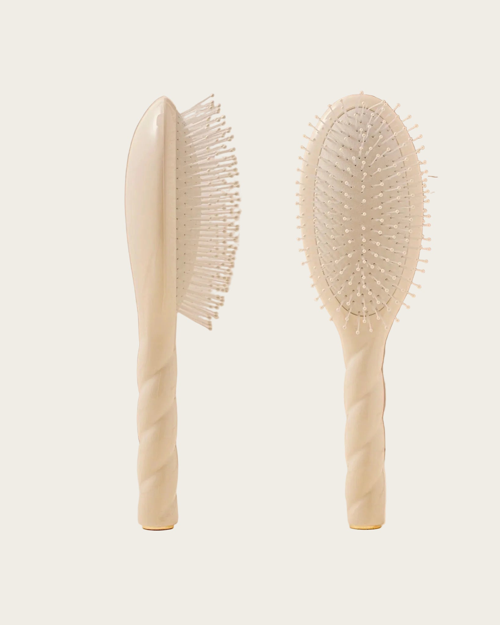 Two beige hairbrushes on a beige background with a 'Marie Claire Hair Awards Winner' badge.