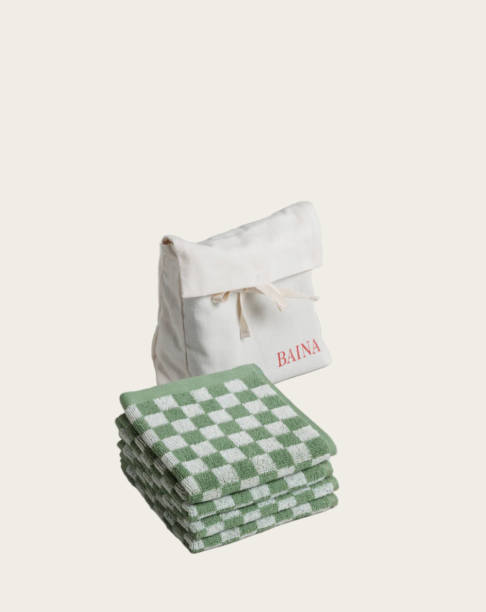 Stack of green and white checkered towels with a white drawstring bag labeled 'BAINA' on a gray background.