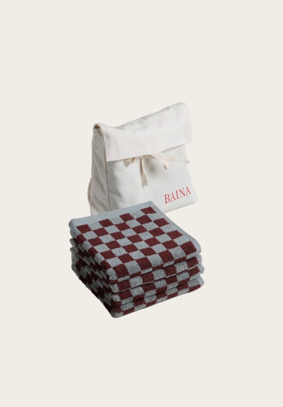 Stack of checkered towels with a branded bag on a light gray background