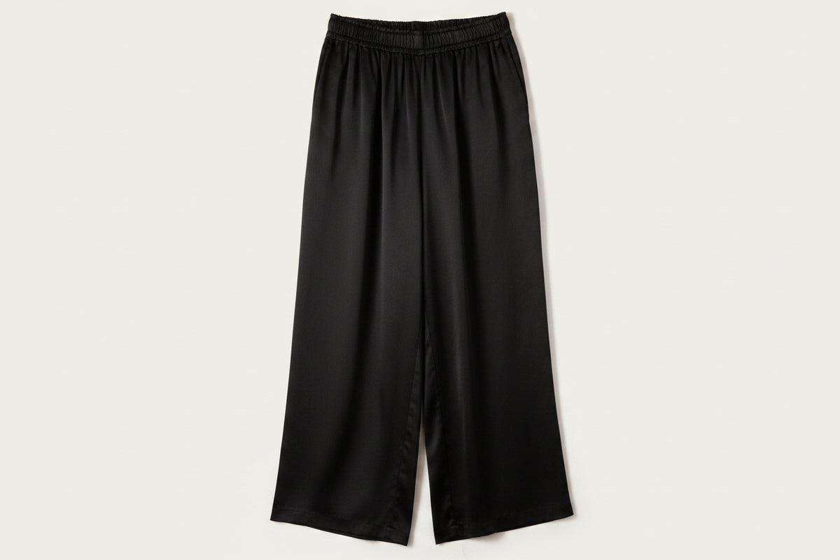 A pair of loose, wide-leg pants in a vibrant royal blue color, featuring an elastic waistband and a relaxed, draped silhouette, shown against a plain off-white background.