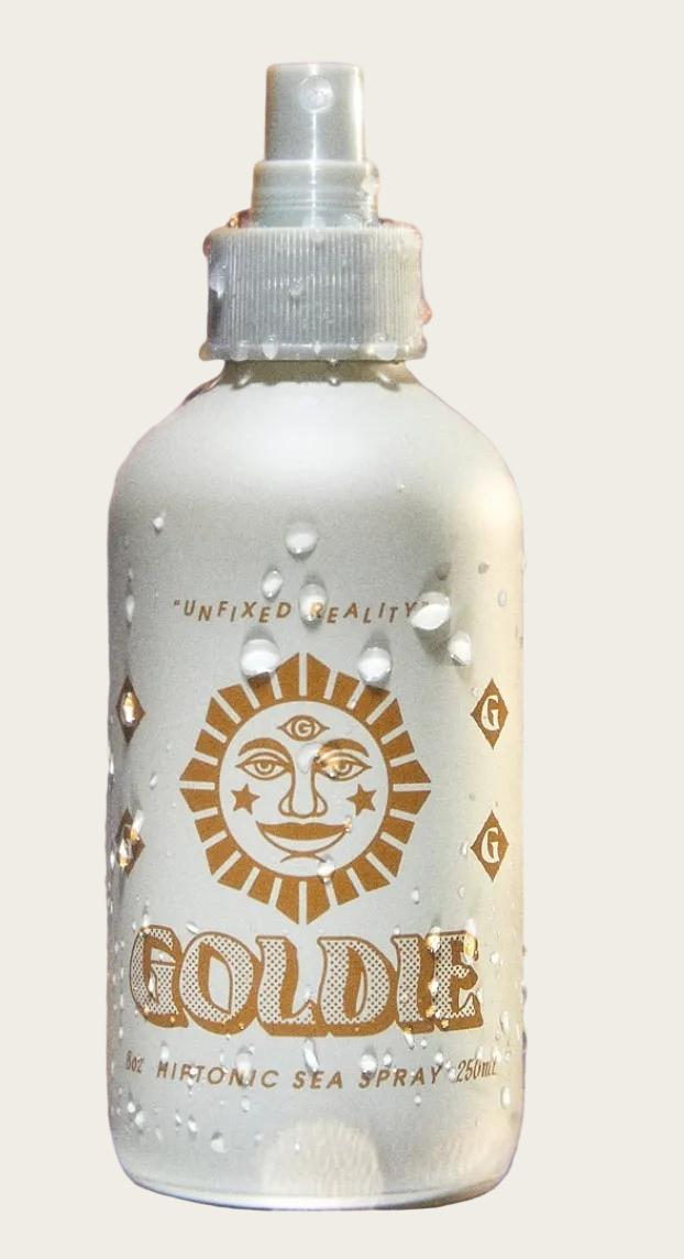 Frosted bottle labeled 'Goldie' with a sun design on a blurred background