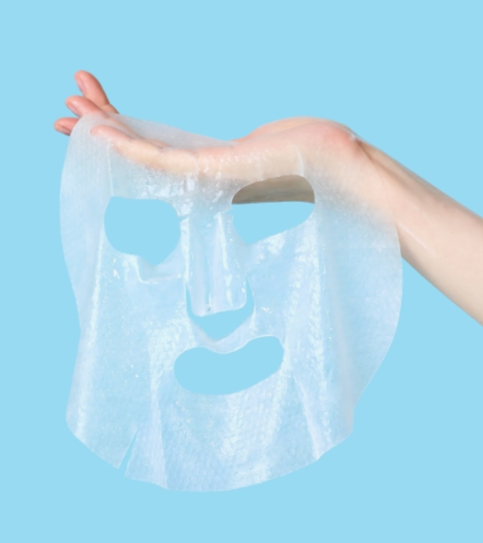 A translucent, semi-permeable hydrocolloid sheet mask being held up by a hand against a solid light blue background.